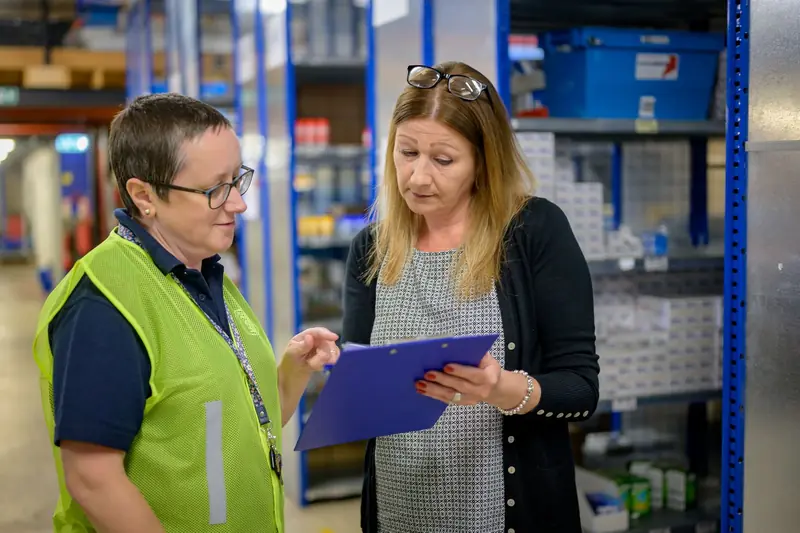 Consultant reviewing stock plans with a warehouse team member